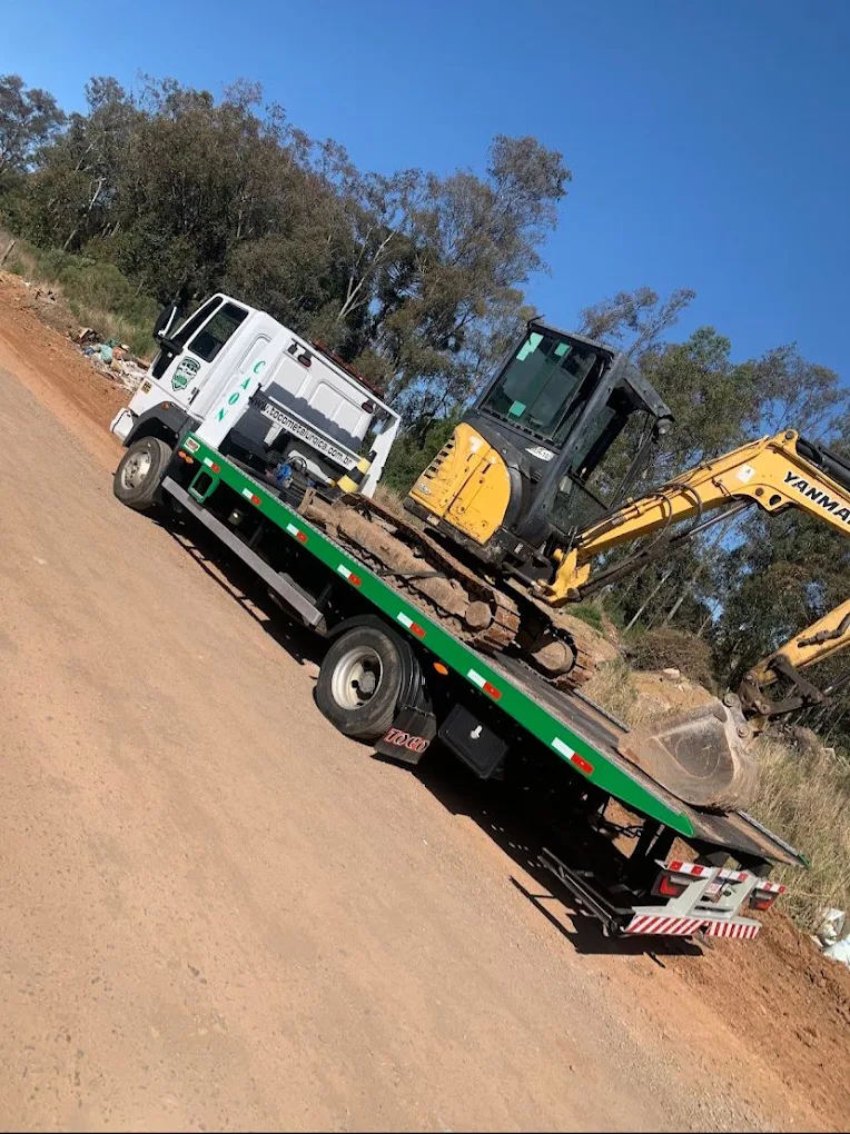 Transporte de mini escavadeira sobre prancha